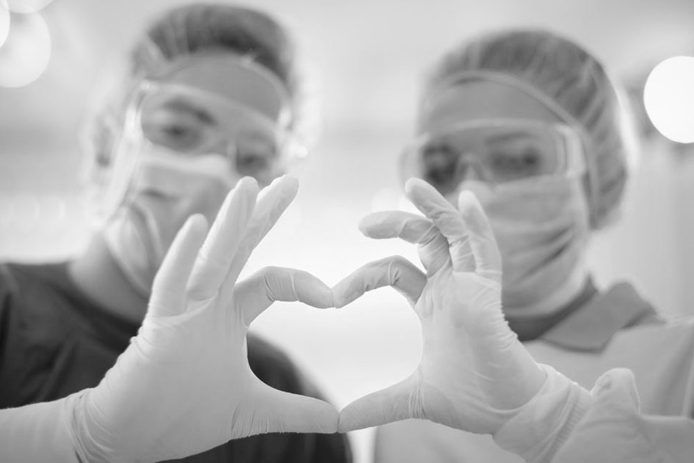 Två läkare som bildar ett hjärta med händerna